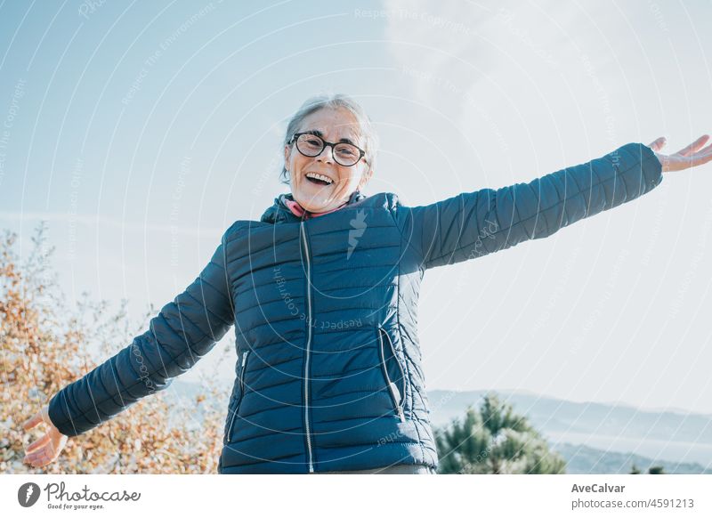 A senior old woman celebrating portrait happy new horizons. Starts new habits for the new year. Trekking and healthy life style.Pensioner woman. Aging, people, active lifestyle and health concept