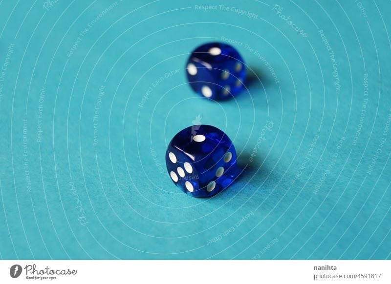 A vibrant monochromatic macro with depth of field about two blue glass gambling dice with two unlucky number one on blue background. game bet monochrome