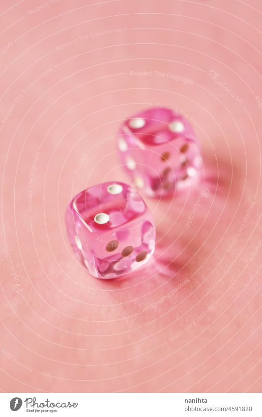 A vibrant monochromatic macro with depth of field about two pink glass gambling dice with two unlucky number two on pink background. game bet monochrome