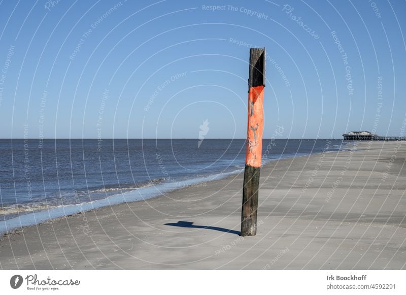 Sea mark on the deserted beach of St. Peter Ording Sky Level Freedom Road marking Sand Island North Sea Red Warning label Far-off places Orientation Signal