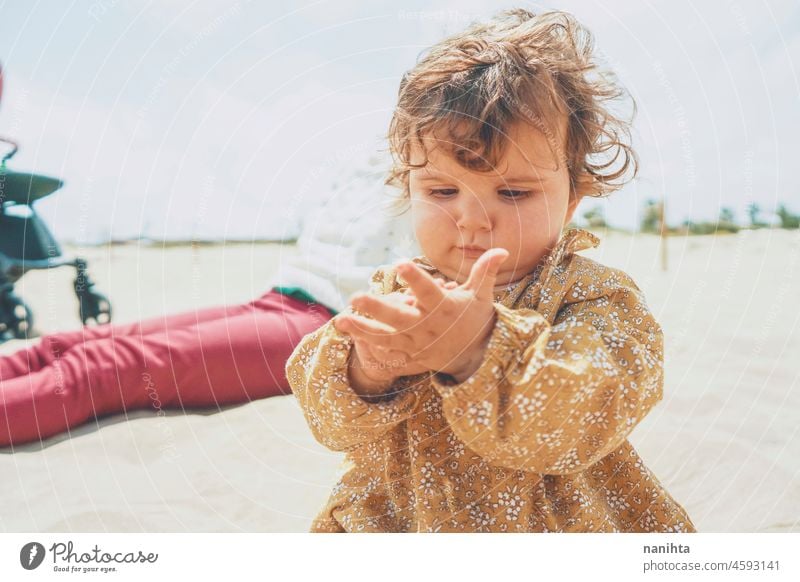 Little girl playing with sand at the beach baby motherhood vacation holidays outdoors sun kid toddler child enjoy warm fun funny portrait sunny warmth hoizon