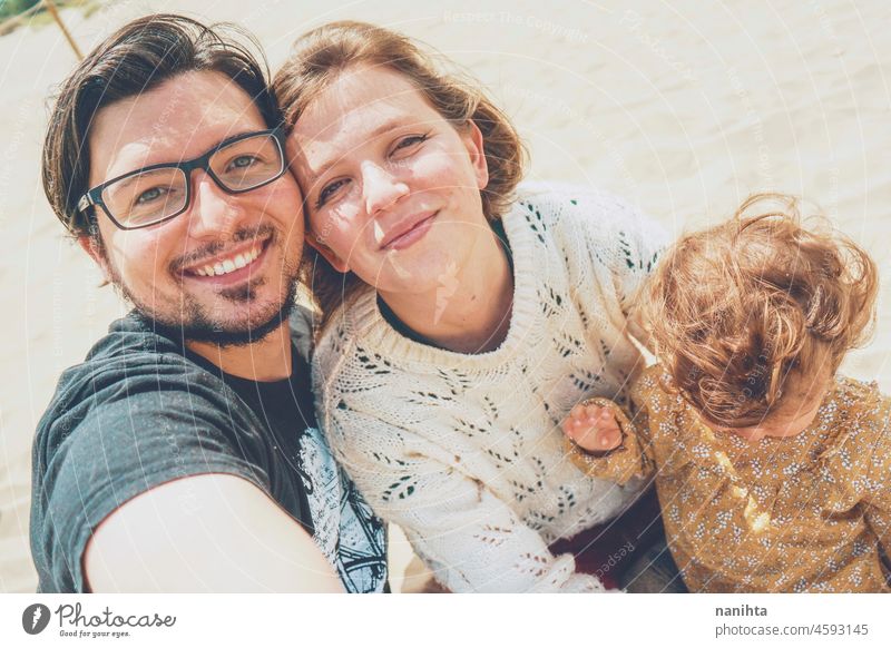 Young family posing together for a selfie in their holidays young happiness love baby parents parenthood smile smiling fun funny joy enjoy real candid life