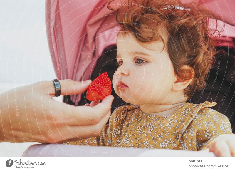 Little baby girl eating a strawberry blw feed fruit learn life face adorable lovely parenting child toddler babyhood nutrition care vitamin delicious temptation