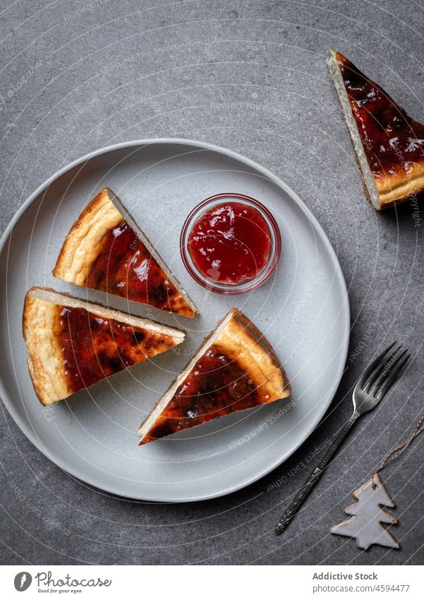Cut cheesecake with jam placed on table sweet dessert tasty nutrition delicious yummy portion jar appetizing food homemade fresh plate dish baked gourmet fork