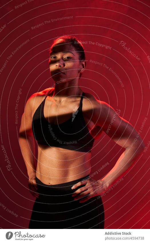 Fit woman sanding hands on hips while training sportswoman workout fitness wellness athlete activity exercise stand portrait smoke practice studio slim