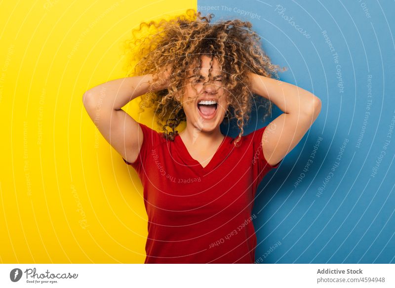 Crazy happy blonde woman with curly hair in studio crazy surprised amazed excited smile cheerful positive optimist young appearance casual style glad bright joy