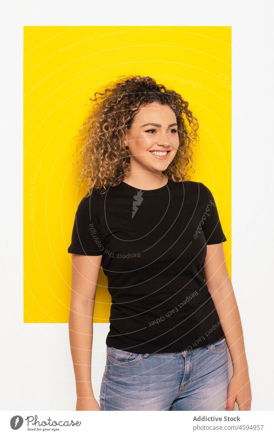 Cheerful blonde woman with curly hair in studio smile cheerful happy positive optimist young appearance casual style glad bright joy portrait colorful