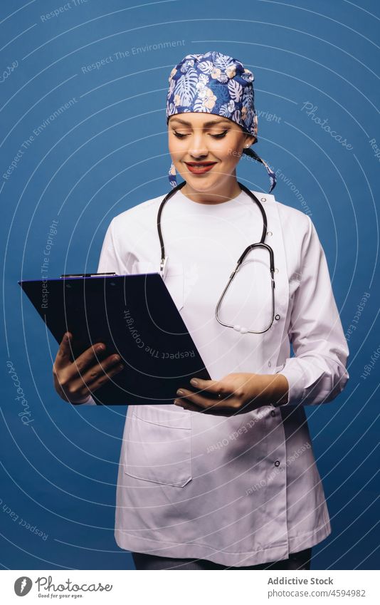 Smiling female doctor in white uniform with stethoscope and folder woman professional robe medical physician smile specialist health care work instrument