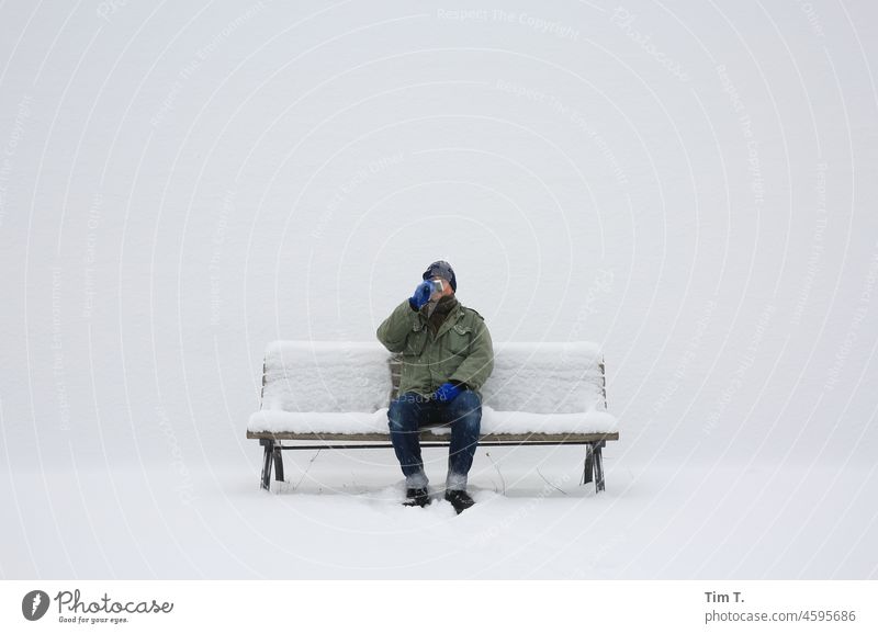a man in the snow on a bench drinking from a flask Winter Snow Man Berlin Bench Drinking Exterior shot Cold Frost Day Colour photo White Calm Alcoholic drinks