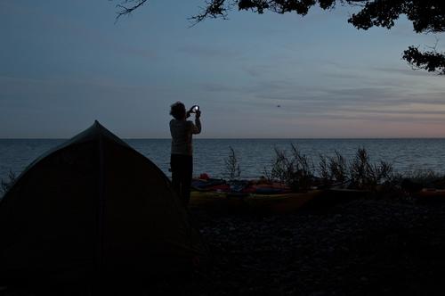 Before she spends the night on the Baltic Sea beach, she photographs the sunset. Canoe Canoe trip canoeing Canoeing Sports Evening Paddling Wind Headwind Water