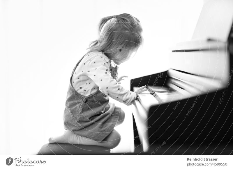 Girl playing the piano Child Toddler Piano Play piano Piano keyboard Music Musical instrument Make music Playing Study Passion Fascinating inquisitive