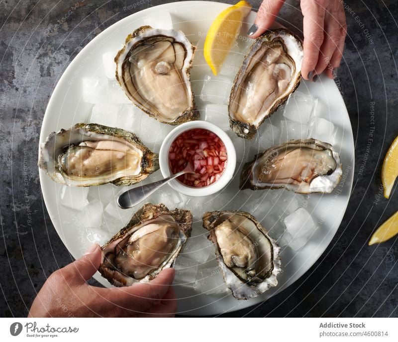 Unrecognizable couple eating oysters in restaurant lemon mignonette seafood gourmet delicious meal fresh appetizing gastronomy yummy sauce tasty cuisine