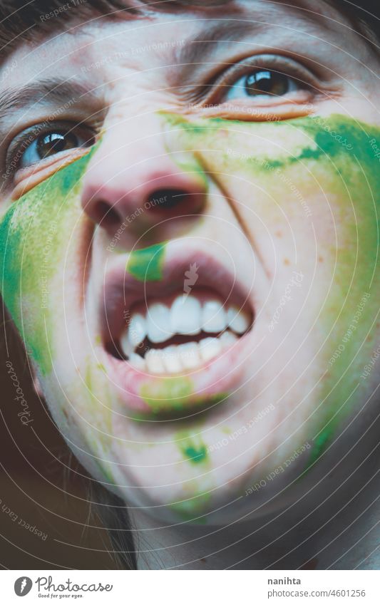 Angry young woman with her face painted with green dust rage anger warrior teeth real painting skin close close up emotion emotional emotive mood intense