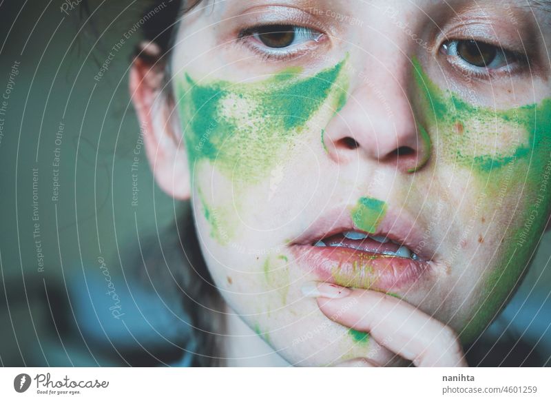 Moody portrait of a young woman with her face painted of green depression depressed hopeless emotional emotive mood intense psychology human human being natural