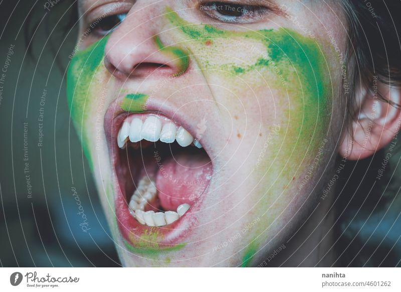 Angry young woman with her face painted with green dust rage anger warrior teeth real painting skin close close up emotion emotional emotive mood intense