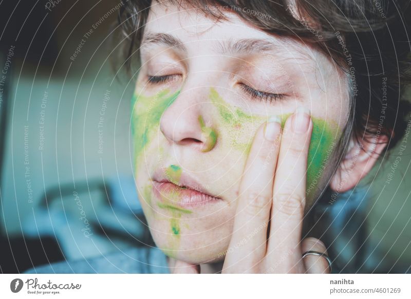 Moody portrait of a young woman with her face painted of green depression depressed hopeless emotional emotive mood intense psychology human human being natural