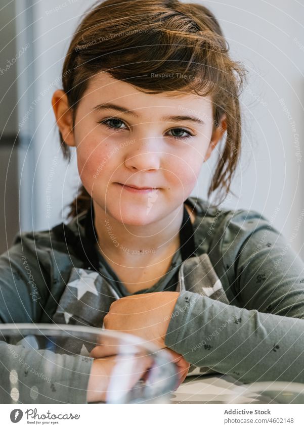 Little girl in apron in kitchen cook home kid domestic prepare child kitchenware culinary brown hair blue eyes at home charming cute innocent gaze helper