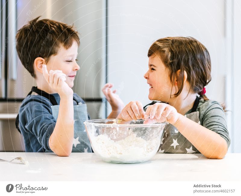 Kids mixing dough in bowl together sibling kitchen cook culinary flour children kitchenware brother sister knead hand homemade pastry make apron bakery kid food