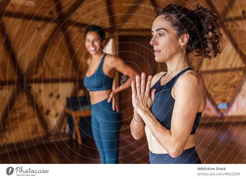 Women practicing yoga in studio women namaste salute asana session practice healthy lifestyle meditate wellness mindfulness fit flexible training posture