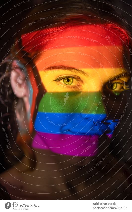 Young lesbian woman under LGBT flag lgbt lgbtq rainbow pride concept female love projector bright colorful illuminate vivid homosexual tolerance support lady