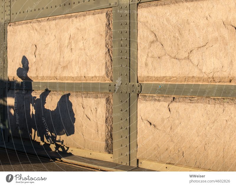 The shadow of a mother with baby carriage on a sunlit old wall Shadow Woman Mother Infancy Child Baby carriage Walking out stroll Wall (building) Sun Light
