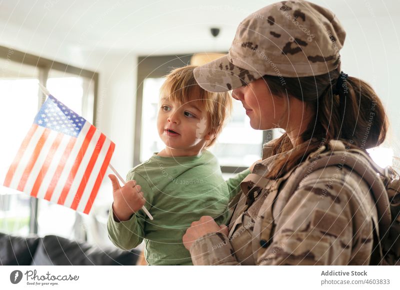 Faceless military woman with son in arms mother soldier duty boy greeting service arrive flag american patriot child cute love together childcare childhood home