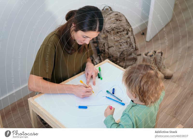 Military mother and son drawing in playroom hobby military soldier boy motherhood leisure childhood care patriot cute love service felt pen together childcare