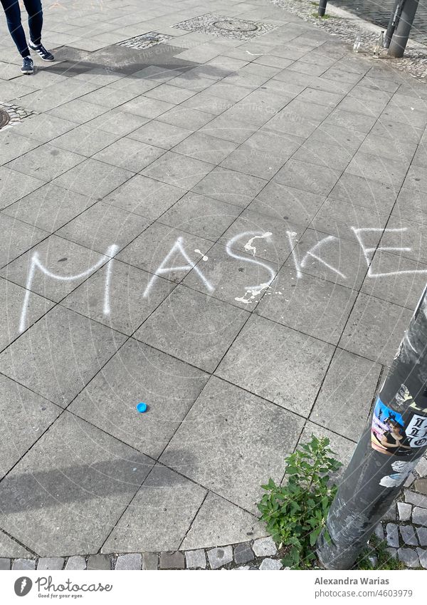 MASKE writing written on a sidewalk in the city of Berlin Mask lettering authored Mask obligation pandemic corona Protection COVID guard sb./sth. prevention