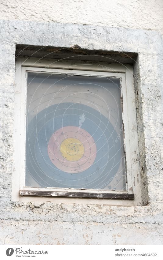 A riddled target behind an old window accurate advantage aim aiming apartment archery board bullseye center challenge circle competition competitive concept