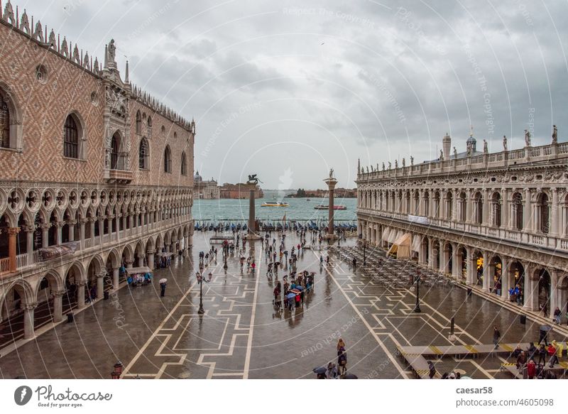 The St. Mark's Square in Venice during Bad Weather and High Tide venice high tide flood umbrella san marco square people baroque cloudy walking water high water