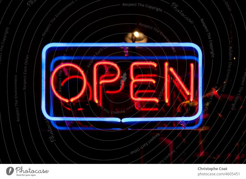 Close-up on a neon light shaped into a blue rectangle and the word "open" in red. Open Sign Neon Store Sign Illuminated Lighting Equipment Retail