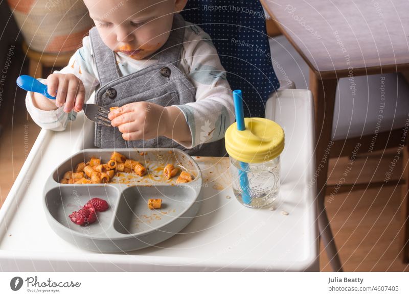 18 month old placing food onto a fork; toddler learning to use a fork utensil to eat pasta baby child 18 months old homemade weaning baby led weaning
