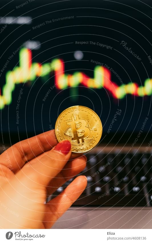 Woman holding a bitcoin coin. In the background are trading candles on a screen. Cryptocurrencies. bit coin Cryptocurrency price crypt Money trade
