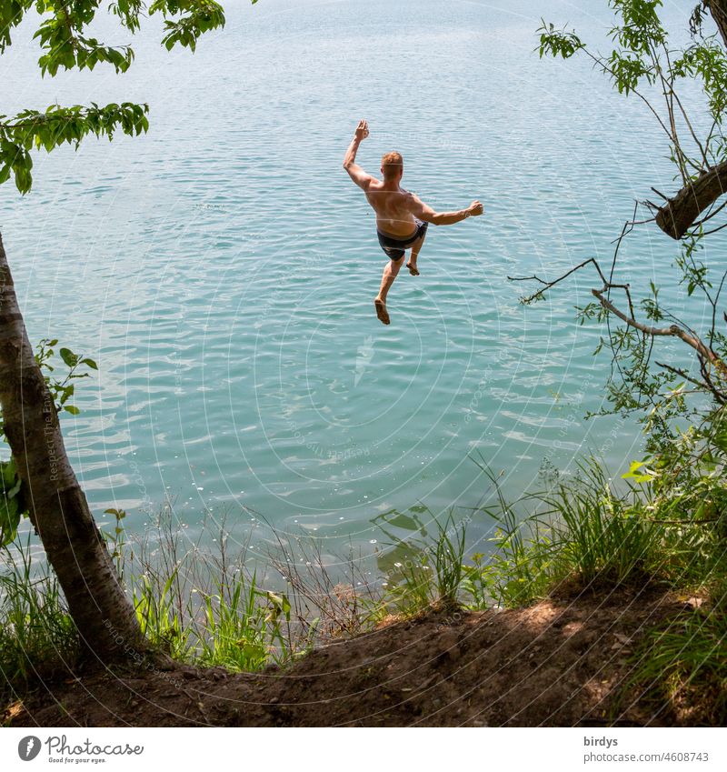 young man jumping into bathing lake in nice weather Lake Holiday at home Jump bathe Water in a dive fun Summer vacation free time Lake Baggersee