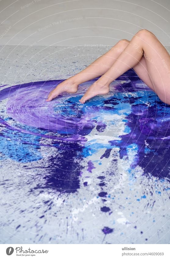 beautiful legs and feet of a sexy young woman ballerina on the artistically abstract purple, blue and white painted studio floor, copy space. magenta color