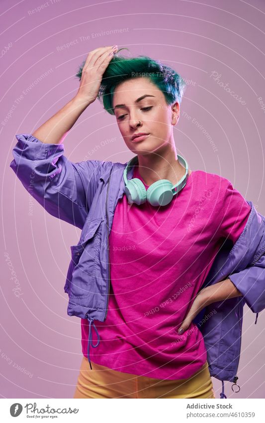Serious informal woman with headphones meloman style millennial 80s fashion design retro studio green hair female model short hair appearance colorful lady