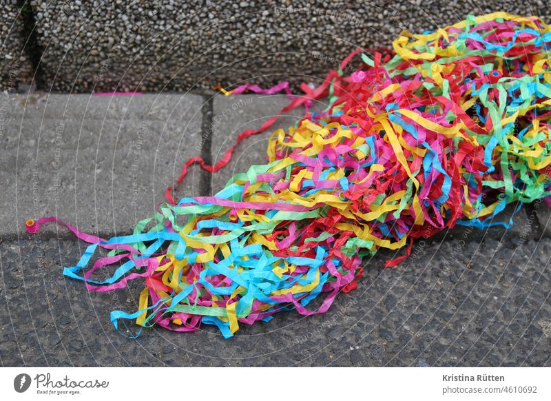 strips of paper from an air snake thrower lie in the gutter Paper streamers Ground Street off Sidewalk Curbstone Party celebration Firm Carnival carnival