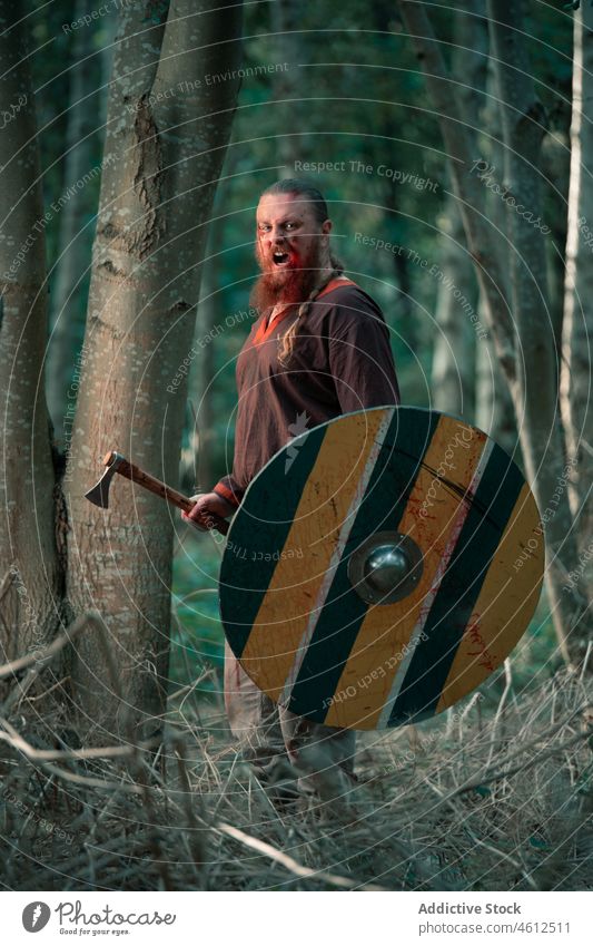 Fearless viking with Scandinavian axe and shield at battle man aggressive angry reenactment force weapon male scandinavian armor reconstruction protect strong