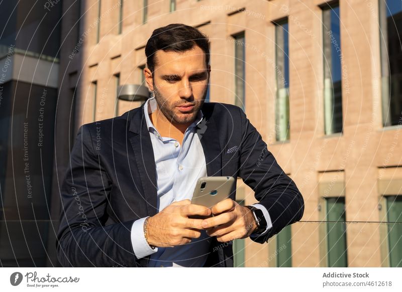 Businessman man using smartphone in suit on sunny street entrepreneur formal city urban male elegant brunet glass fence businessman beard lean well dressed