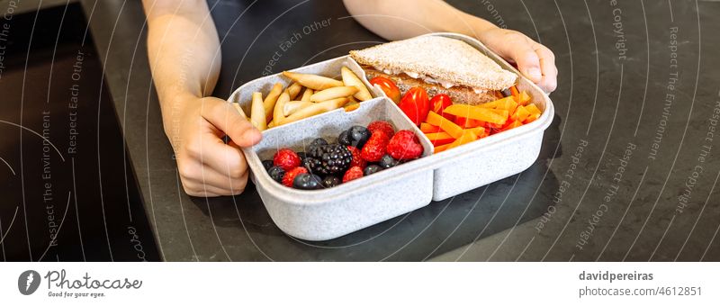 Unrecognizable girl taking lunch box filled with healthy food unrecognizable vegetarian healthy snack veganism take-away lunch box compartments school