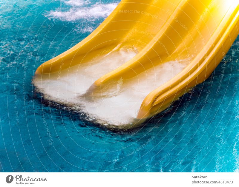 Yellow water slide in the water park waterpark pool yellow relaxation summer activity plastic color aqua travel happiness outdoors sport leisure wet flowing