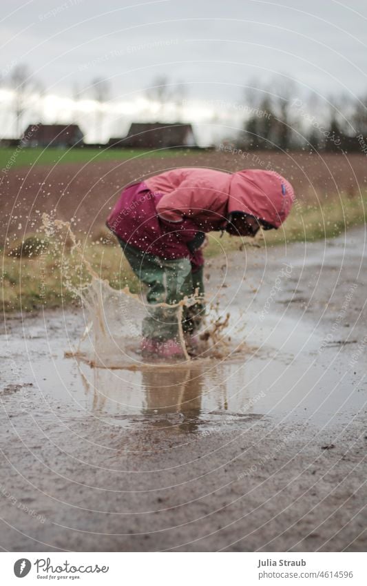 Girl jumps in giant puddle Rainy weather Comfortless Infancy Child Kindergarten Playing Romp out be out fortunate Brash splat Wet Water Effervescent cold season