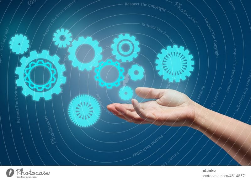 gear wheels and female hand on a blue background. Business structure precise work concept, team unification business person engineering technology teamwork