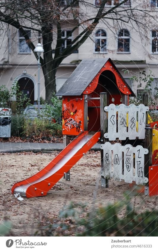 Playground with red slide in urban environment Red Slide cot Fence Sand Facade Town Infancy Playing Joy Child Toys graffiti Kindergarten Sandpit Children's game