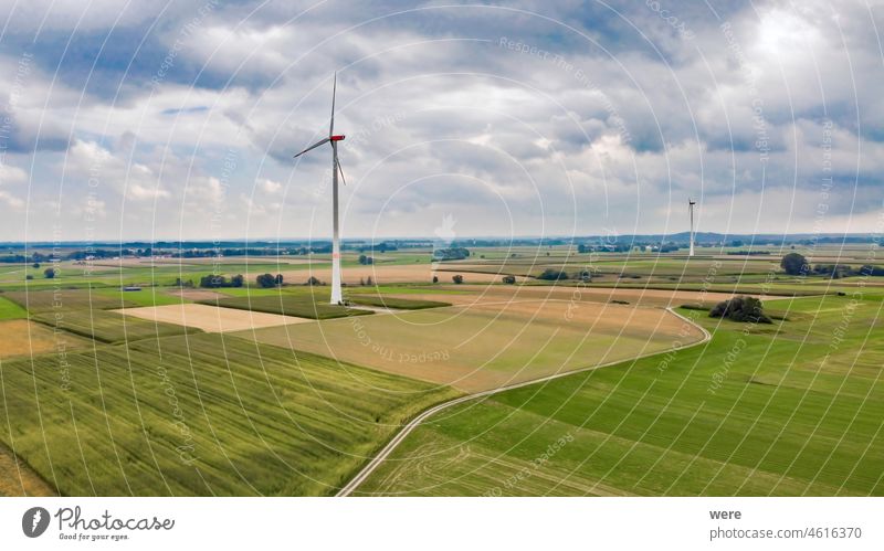 Wind turbines in stormy cloudy sky in agricultural landscape Alternative Energy Area flight View Wind power aerial view agricultural area bird's eye view