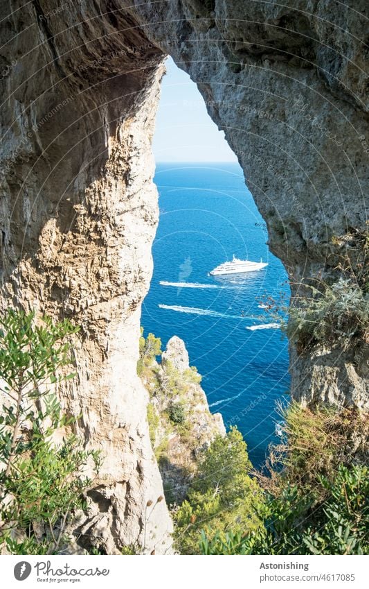 Natural gateway to the sea Landscape Nature fissure Arco naturale Capri Ocean Mediterranean sea boat boats ships Rock stones steinformation Green Blue Horizon