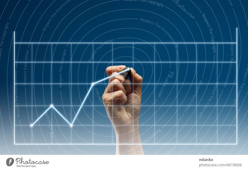 holographic graph with growing indicators and a woman's hand with a marker on a dark blue background. Profitability, success and income growth concept goal