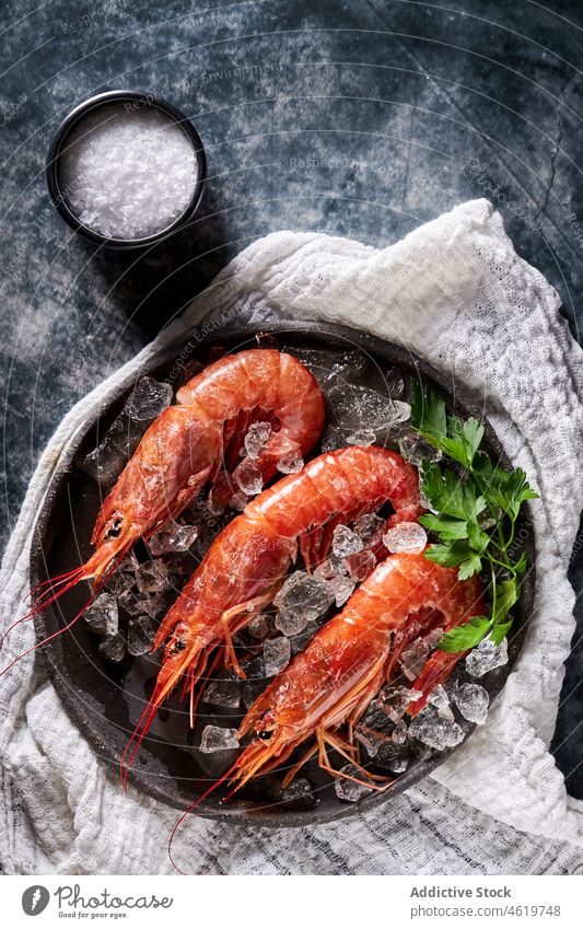Shrimps in bowl with ice and parsley on napkin shrimp prawn seafood delectable palatable luxury gourmet dish meal tasty fresh cuisine delicious ingredient