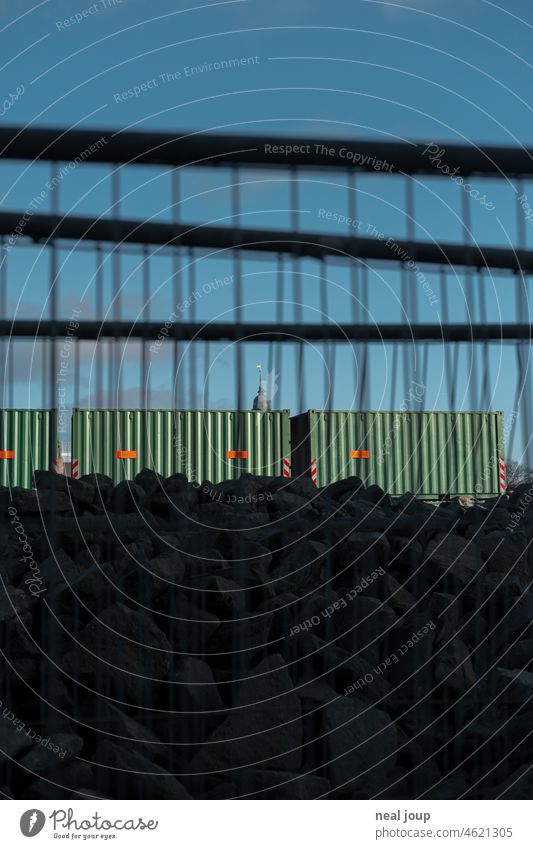 Trashy view through construction lattice on Hamburg's Michel, which peeks out from behind a few containers Construction site structure Grating building grid