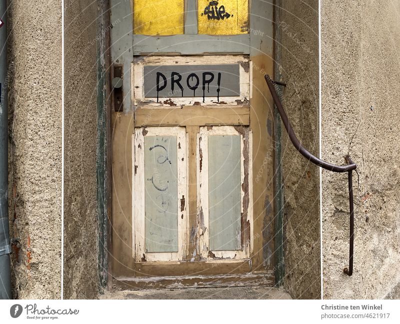 DROP! is written on the peeling front door of the old neglected house drop Word Letters (alphabet) Write writing Remark Text Compromise Communicate